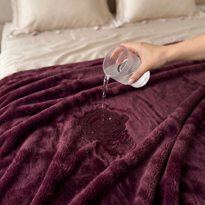pouring water on plum colour freak sheet waterproof blanket